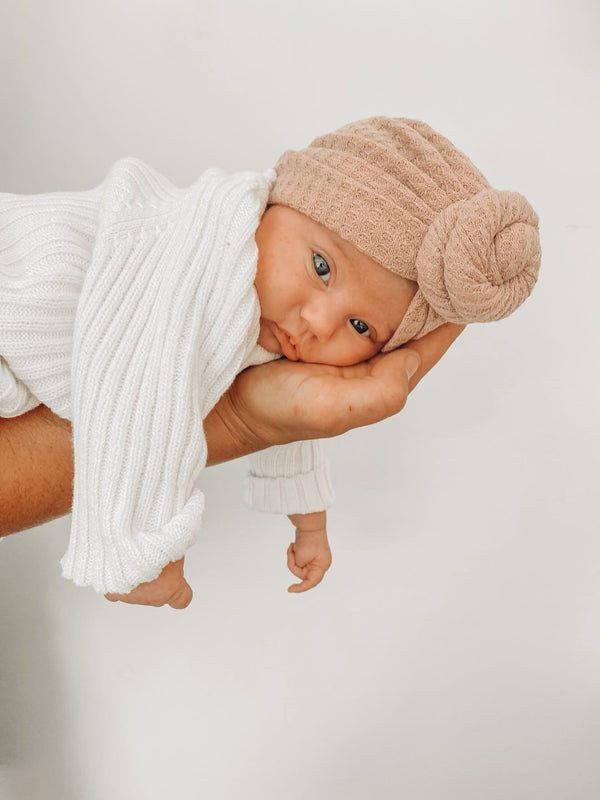 Baby wearing a soft chocolate brown waffle knot turban