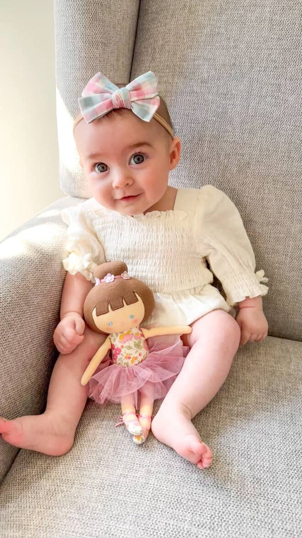 baby sitting on a chair in our cute Sadie Gingham bow