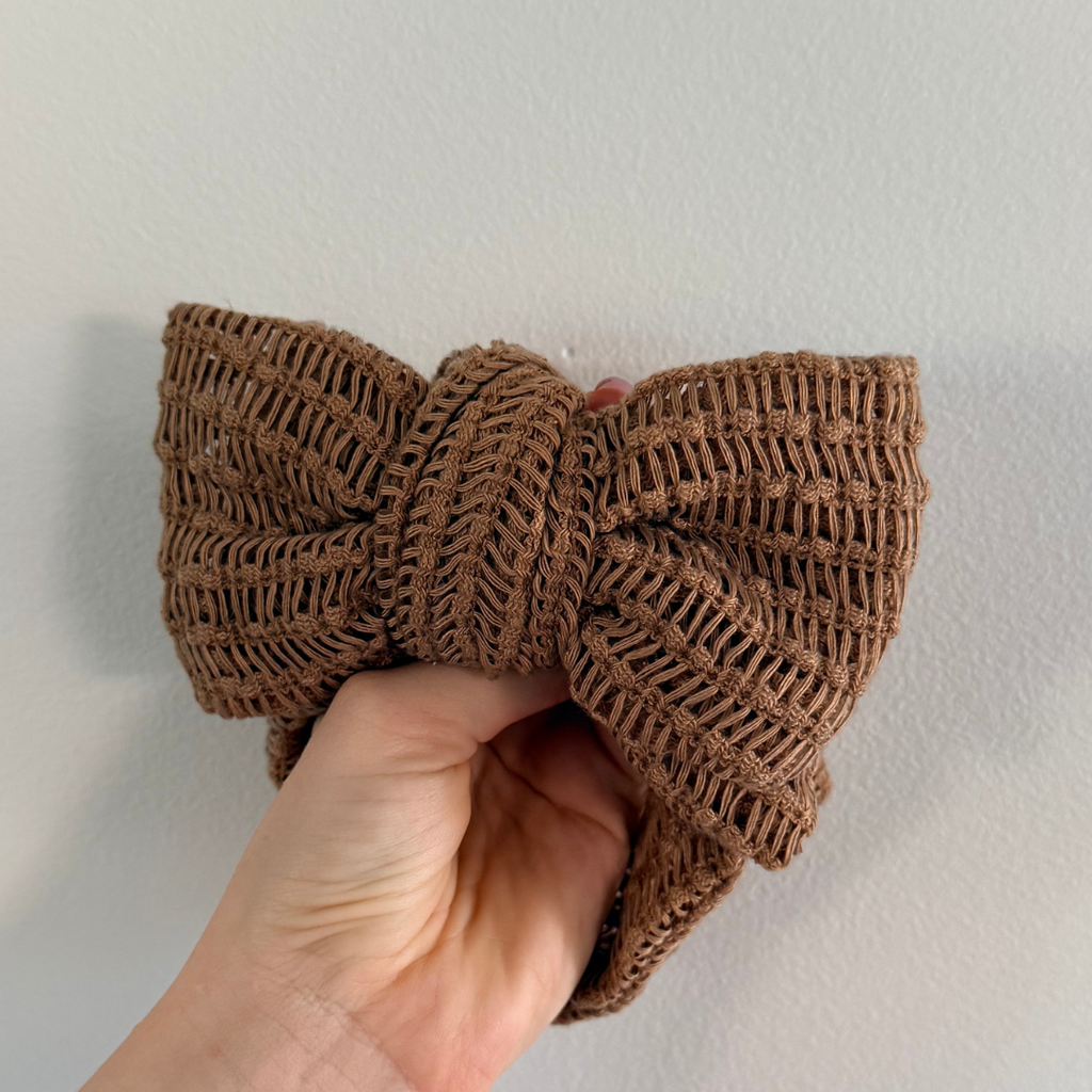 Close-up of a chocolate brown crochet topknot showing the knit texture