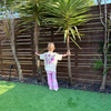 Toddler in the Cosmic Stardust Set with a Butter tee and pink tie-dye flares, showing the moon and star back print
