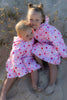Kids cuddling wearing Mae and Rae Zahli hooded towel after swimming at the beach 