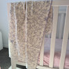 Lilac Vine crepe cotton swaddle with scalloped edge, draped over a white cot