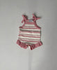 Lulu pink and white striped knit romper with tie straps and frill legs, laid flat